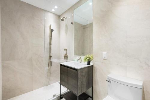 a bathroom with a toilet and a sink and a shower at Global Luxury Suites at The Arches in Bronx