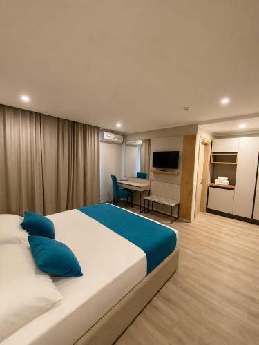 ein Hotelzimmer mit einem großen Bett und einem Schreibtisch in der Unterkunft Hotel Rhodos in Eforie Nord