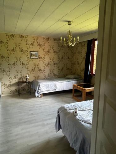 a bedroom with two beds and a chandelier at Martan Porti Three-bedroom house in Imatra