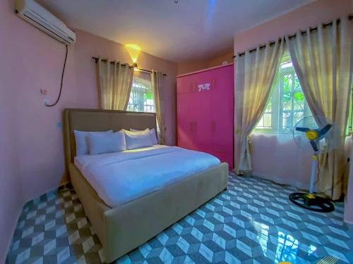 a bedroom with a bed with blue and pink at Imtech Luxury Apartments in Uyo