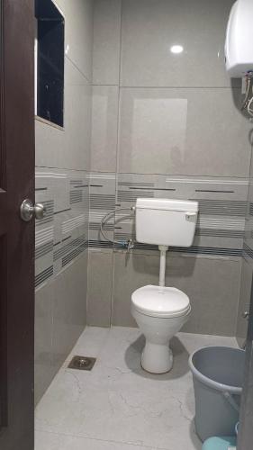 a bathroom with a toilet and a glass wall at The Hilltop inn in Kelghar