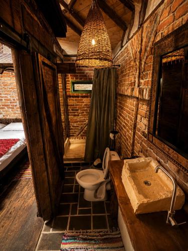 a bathroom with a toilet and a sink and a tub at La Colibe, cătun arhaic ecologic in Corbu