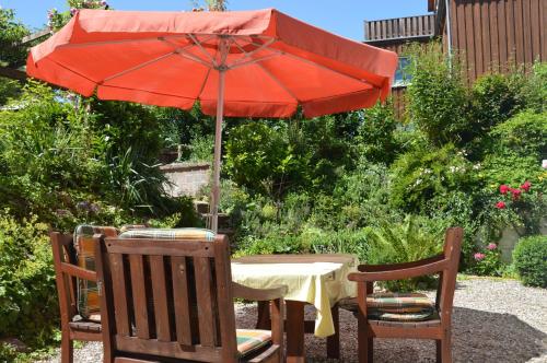 a table with a red umbrella and two chairs at Zaumseil, Axel Fe-App "unten" in Schönberg