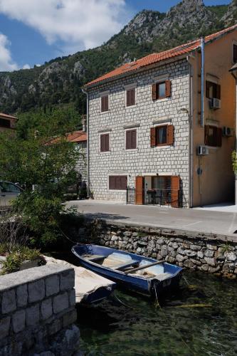 a blue boat in the water next to a building at Historic Waterfront Apartment in Muo