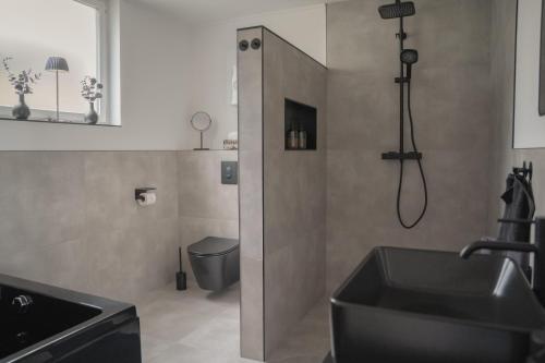 a bathroom with a shower and a sink and a toilet at Ferienwohnung Eifelmomente in Rittersdorf