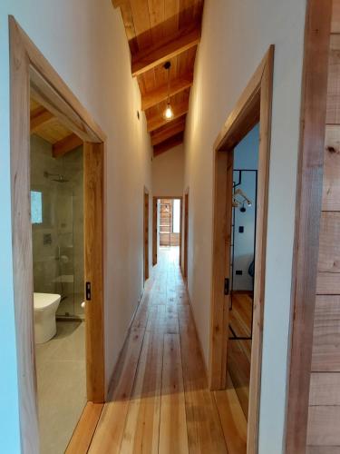 a hallway of a house with wooden floors and a bathroom at Chalet Ciprés in Las Trancas