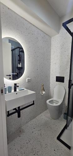 a bathroom with a toilet and a sink and a mirror at Blu Marine Loano -Terrazza Vista Mare- in Loano