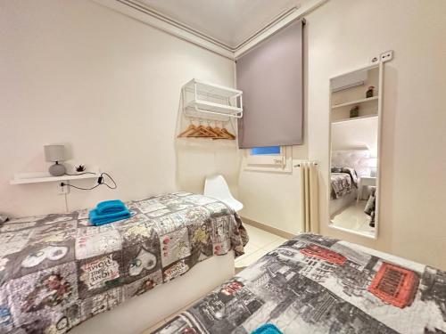 a bedroom with two beds and a refrigerator at Rooms Granvia in Barcelona