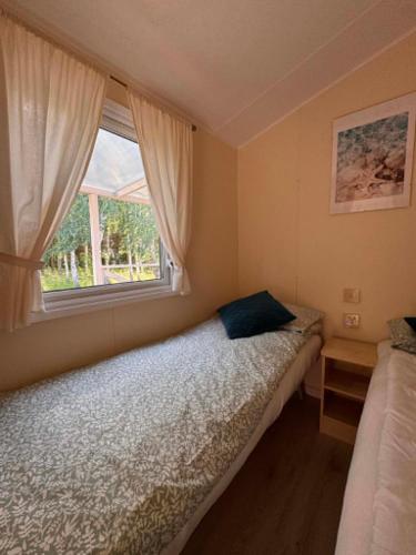 a small bedroom with a bed and a window at Między polami in Drewnica