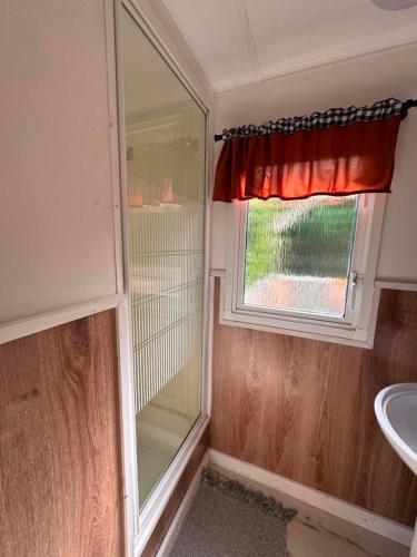 a bathroom with a shower and a window and a sink at Między polami in Drewnica