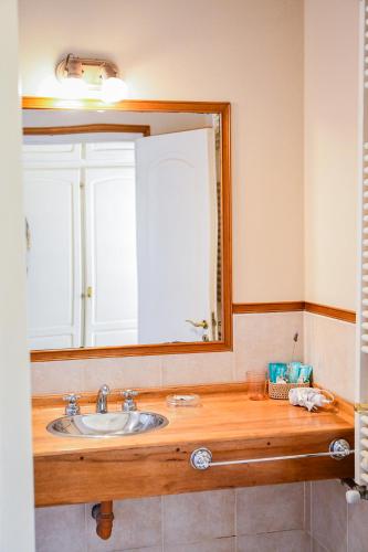a bathroom with a sink and a large mirror at Hostería La Viña in La Cumbre