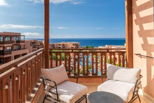 a balcony with two chairs and a view of the ocean at Barceló Tenerife Royal Level in San Miguel de Abona