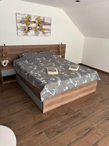 a bed in a bedroom with a wooden floor at Zelena reka 3 in Simici