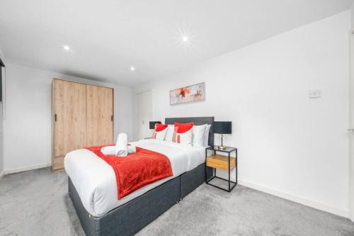 a bedroom with a large bed with red and white pillows at 3-Bed Home in East Kilbride Ideal for Contractors & Longer Stays from Voyage Collection in East Kilbride
