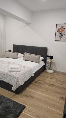 ein Schlafzimmer mit einem Bett und einem Holzboden in der Unterkunft Apartman Anđa in Široki Brijeg