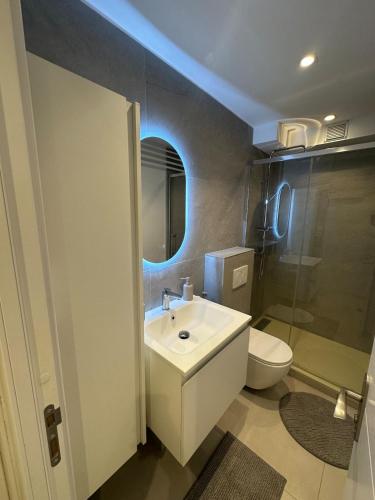 a bathroom with a white sink and a toilet at Studio du Lac in Créteil