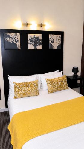 a bedroom with a large bed with a yellow blanket on it at Mapungubwe Hotel in Johannesburg