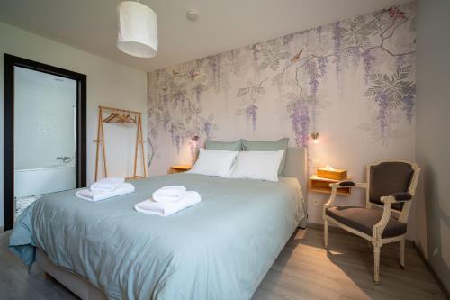 a bedroom with a large bed with towels on it at L'Oasis d'Yza in Gedinne