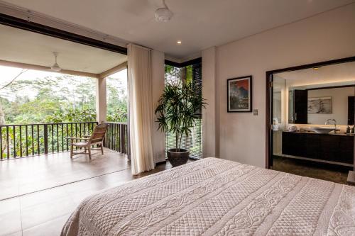 een slaapkamer met een bed en een balkon bij Villa Naga Putih in Ubud