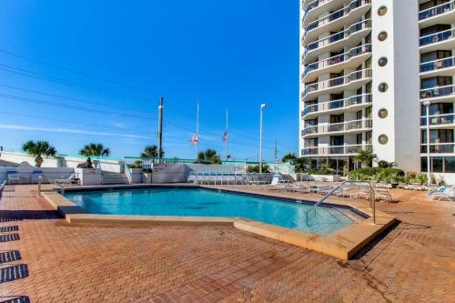 a swimming pool in front of a tall building at Gorgeous and well appointed efficiency with shared pool and beach access in Destin