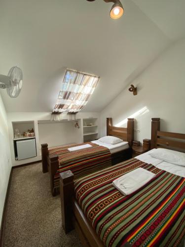 a hotel room with two beds and a window at Stizhok Hotel & Restaurant in Berkhomet-pe-Siret