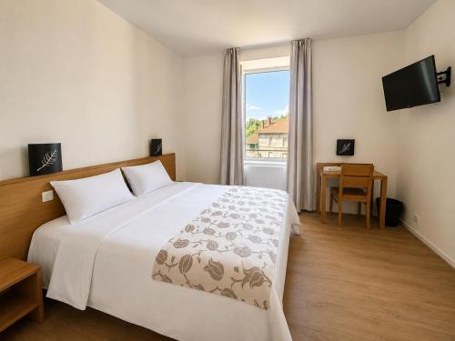 a bedroom with a large white bed and a window at L'Eden du Forez in Le Brugeron