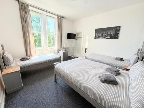a room with three beds and a window at The Windsor Hotel and Bar in Kirkcaldy