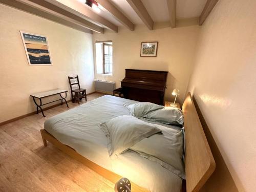 a bedroom with a large bed and a piano at Escapeteu in Azur