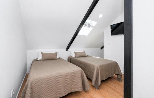 a attic bedroom with two beds and a mirror at Solar da Fé in Atalaia