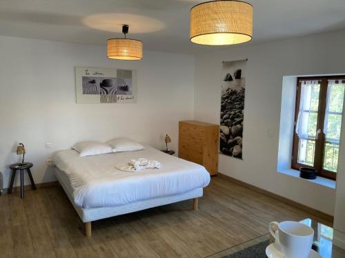 a bedroom with a bed with white sheets and two lights at Aparthotel Des 2 Caps in Ambleteuse