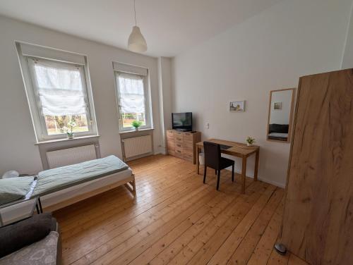 a bedroom with a bed and a desk with a computer at Zimmervermietung an der Bebra in Sondershausen