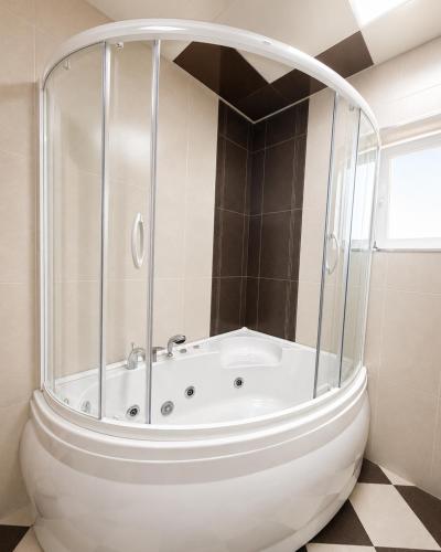 a white tub in a bathroom with a window at Bilgah Coast Villa in Baku
