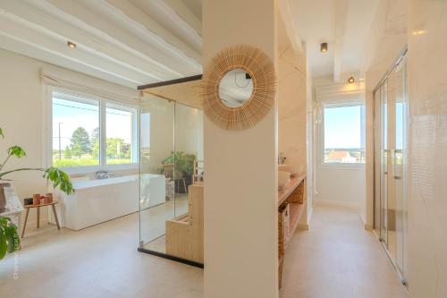 a bathroom with a tub and a sink and a mirror at La Bali, Luxe et relaxation in La Ferté-Gaucher