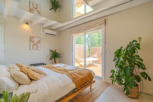 a bedroom with a large bed and a large window at La Bali, Luxe et relaxation in La Ferté-Gaucher