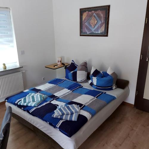 a bedroom with a bed with blue and white pillows at Ferienwohnung in Spreewaldnähe in Kolkwitz