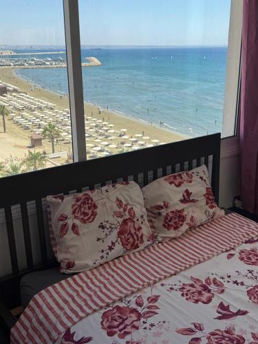a bedroom with a bed and a view of the beach at Larnaca Seaview Rooms in Larnaca