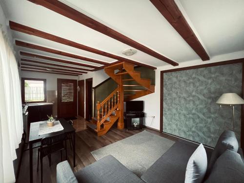 a living room with a couch and a staircase at Hanga Apartments in Sovata