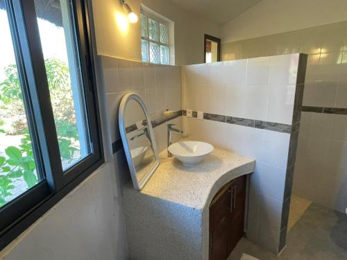 a bathroom with a sink and a mirror on a counter at Les Cases Rouges in Kaolack