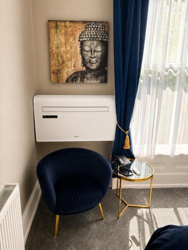a room with a blue chair and a picture of a head at Hedley House Hotel Wellness and Spa in York