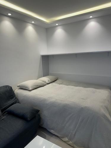 a bedroom with a bed and a couch at Studio du Lac in Créteil
