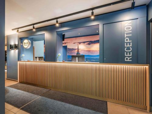 a store front with a wooden bar in a lobby at B&B Hotel Freiburg-Süd in Freiburg im Breisgau