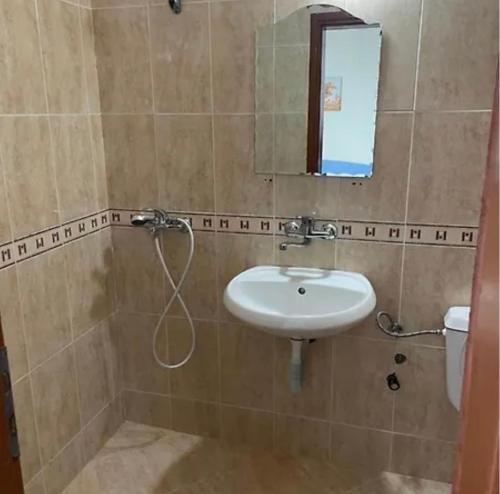 a bathroom with a sink and a mirror and a toilet at Angel in Primorsko
