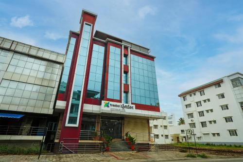 a large building with glass windows on a street at Treebo Ksheera Residency Near Railway Station in Hassan