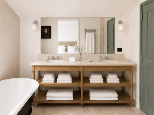 a bathroom with two sinks and a large mirror at Domaine de Fontenille - Fontenille Collection in Lauris