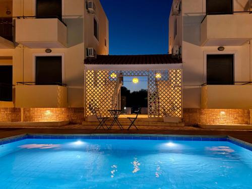 a swimming pool in a villa at night at Oliva Holiday Homes in Dhiyeliótika