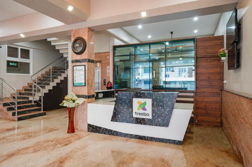 a lobby of a building with a clock on the wall at Treebo Ksheera Residency Near Railway Station in Hassan