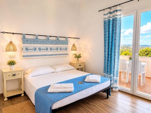 a bedroom with a bed and a large window at BeB con piscina Villa del Borgo in Badesi