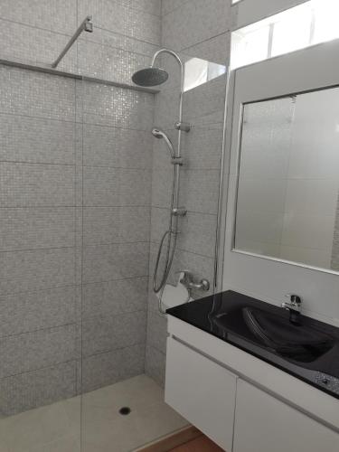 a bathroom with a shower with a sink and a mirror at Casa Bela in Sagres