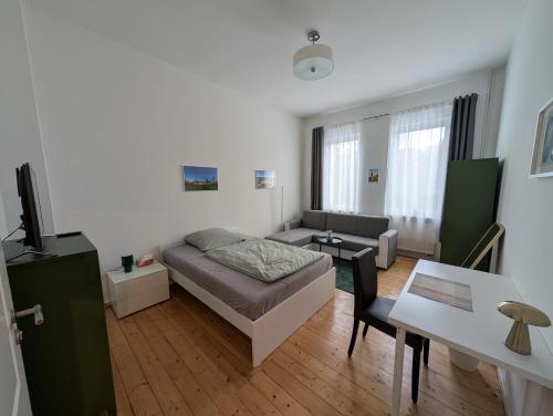 a bedroom with a bed and a table and a couch at Zimmervermietung an der Bebra in Sondershausen