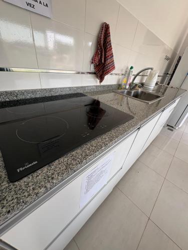 a kitchen counter with a sink and a stove at Departamento Temporal con Cochera in Paraná